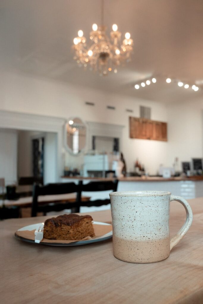 coffee mug and a pastry with a chandalier in the background at anchor house coffee roasters
