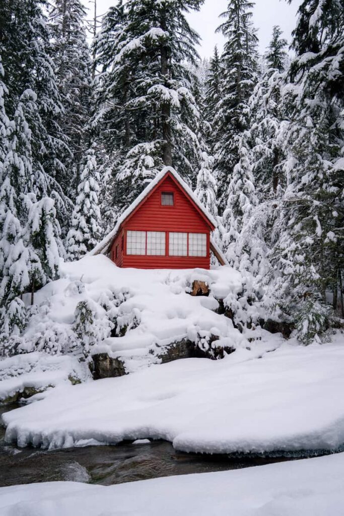 Red-cabin-covered-in-snow-sitting-above-river-at-franklin-falls