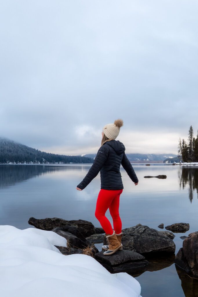 woman standing on rock by shore at lake wenatchee state park